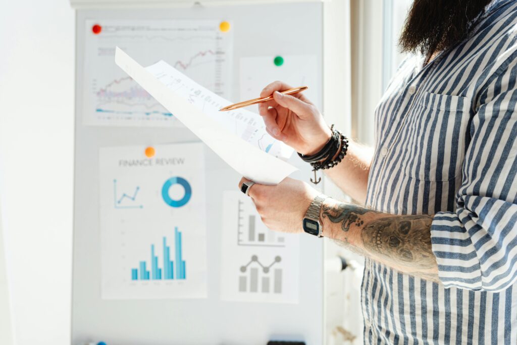 Professional reviewing financial graphs and documents in a bright office setting.
